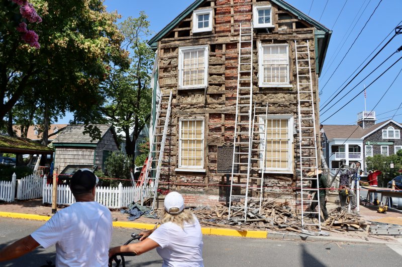 John and Oxana Curry of Pennsylvania stop to look at the renovations being done to the Cannonball House at Front and Banks streets in Lewes July 30. The project is the first phase of a multi-phase restoration of the landmark building, which was built in 1760. BILL SHULL PHOTOS